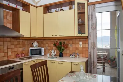 a kitchen with yellow cabinets and a table with a microwave at Castel View Experience in Kissamos