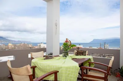 a table and chairs on a balcony with a view of the ocean at Castel View Experience in Kissamos