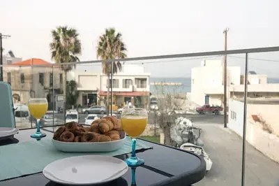 a table with two glasses of orange juice and a bowl of doughnuts at Aria apts 100 m from the beach by PosarelliVillas in Kolymvari