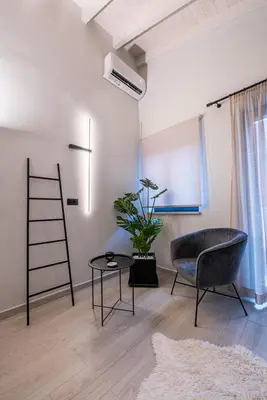 a living room with a chair and a table at Chania Residence - City centre maisonette in Chania Town