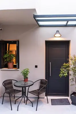 a patio with a table and chairs and a black door at Chania Residence - City centre maisonette in Chania Town
