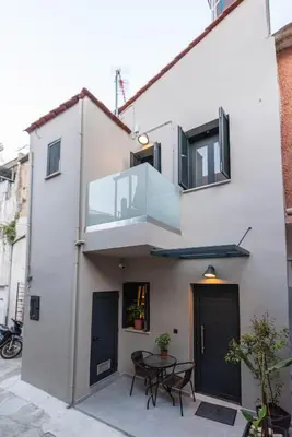 a white house with a balcony and a table at Chania Residence - City centre maisonette in Chania Town