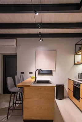 a kitchen with a sink and a counter with chairs at Chania Residence - City centre maisonette in Chania Town
