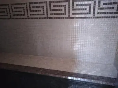 a bathroom with a shower with white tiled walls at Aphrodite View in Korakiaí