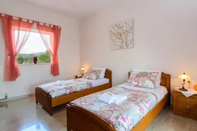 two twin beds in a room with a window at Villa Albion in Kolymvari