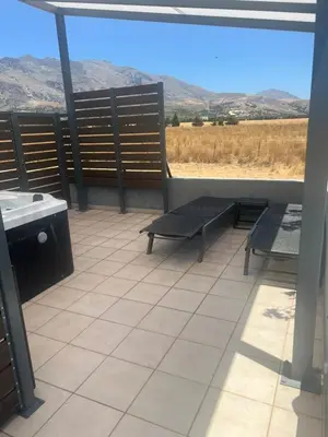 a balcony with benches and a view of a field at Ledakis House with Jacuzzi in Frangokastello