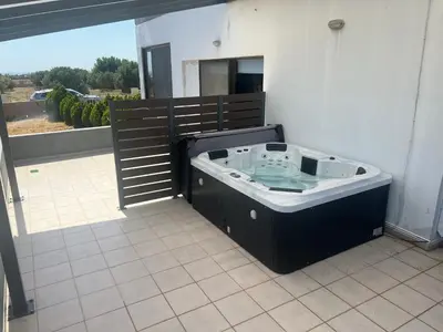 a large bath tub sitting in the middle of a patio at Ledakis House with Jacuzzi in Frangokastello