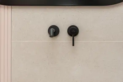 a cabinet with black handles on a wall at Esperanto Seafront suites in Agia Marina Nea Kydonias