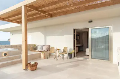 a kitchen and living room with a view of the ocean at Esperanto Seafront suites in Agia Marina Nea Kydonias