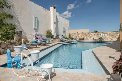 a swimming pool with chairs next to a building at Villa Kritiko Archontiko in Koprána