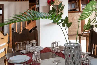 a table with plates and glasses and a vase at Villa Kritiko Archontiko in Koprána