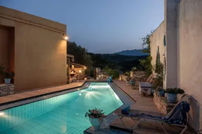 a swimming pool with chairs and a building at Villa Kritiko Archontiko in Koprána