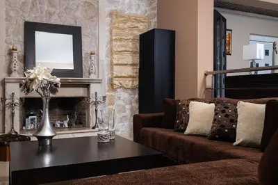a living room with a couch and a fireplace at Villa Kalaitsidi - plunge pool, gym and unique gardens in Skinés