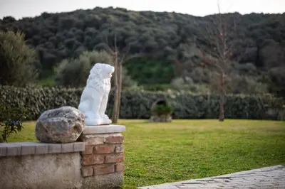 a statue of a white cat sitting on a brick wall at Villa Kalaitsidi - plunge pool, gym and unique gardens in Skinés