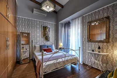 a bedroom with a bed and a mirror and a window at Villa Milon by PosarelliVillas in Skinés