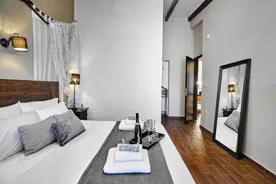 a bedroom with a large white bed with a mirror at Villa Milon by PosarelliVillas in Skinés