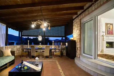 a living room with a table and a couch at Villa Milon by PosarelliVillas in Skinés