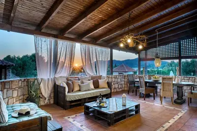 a living room with a couch and a table at Villa Milon by PosarelliVillas in Skinés