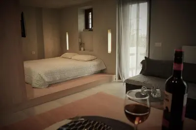 a bedroom with a bed and a bottle of wine at Saxon's Apartment in Chania Town