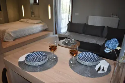 a living room with a table with two glasses of wine at Saxon's Apartment in Chania Town