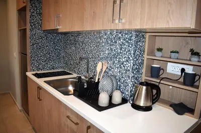 a kitchen counter top with a sink and a stove at Saxon's Apartment in Chania Town