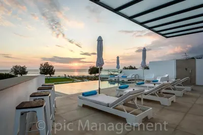 a villa with a view of the ocean at sunset at Seafront VILLA PELAGIA SUPERB New listing in Chania Town