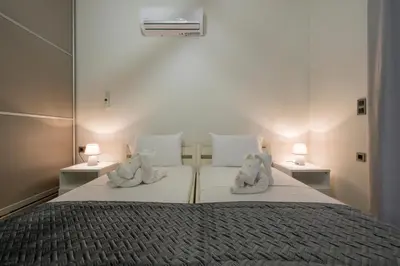 two teddy bears sitting on a bed in a bedroom at Cataleya Villa Chania in Daratso
