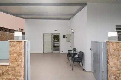 a hallway with a table and chairs in a building at Cataleya Villa Chania in Daratso