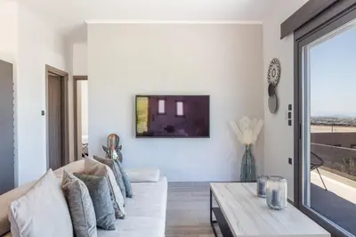 a living room with a couch and a table at ÉTHAFOS Luxury Apartment in Tsikalariá