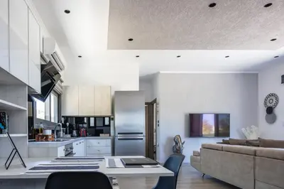 a kitchen and living room with a couch and a table at ÉTHAFOS Luxury Apartment in Tsikalariá