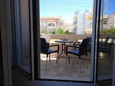 a patio with a table and chairs on a balcony at THALIA APARTMENTS CHANlA in Chania Town