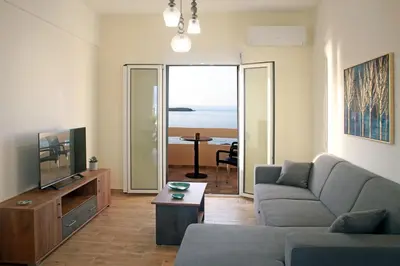 a living room with a couch and a television and a table at THALIA APARTMENTS CHANlA in Chania Town