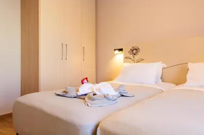 two beds with towels and stuffed animals sitting on them at Vakakis Family Luxury Studios in Palaiochóra