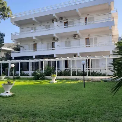 a large white building with a lawn in front of it at Hotel Elman in Palaiochóra