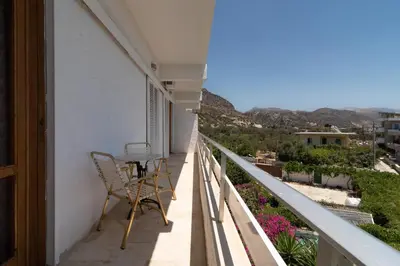 a balcony with a table and a view of the mountains at Hotel Elman in Palaiochóra