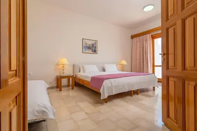 a bedroom with a bed and two lamps and a door at Hotel Elman in Palaiochóra