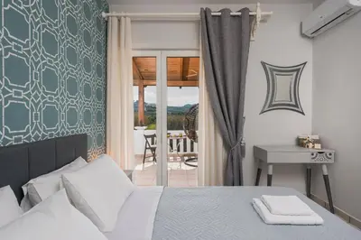 a bedroom with a bed and a table and a balcony at Casa de philippe with unique Seaview 2' from beach in Ayiá
