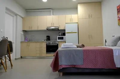 a kitchen with a table with a pink blanket on it at Erinaki Apartments in Kissamos