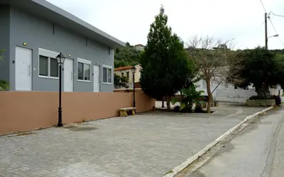 a building with a bench next to a street at Erinaki Apartments in Kissamos