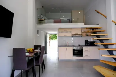 a kitchen and dining room with a staircase in a house at Erinaki Apartments in Kissamos