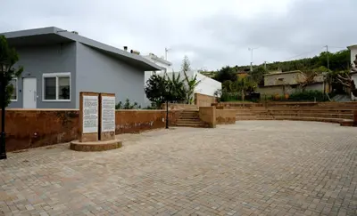 a white building with stairs and a brick courtyard at Erinaki Apartments in Kissamos