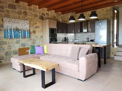a living room with a couch and a kitchen at New Villa Kalimera, view to Falasarna beach in Plátanos