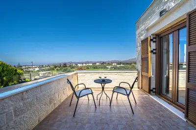a patio with a table and chairs on a balcony at FOS residence - ΦΩΣ ,luxury villa in Chania Town