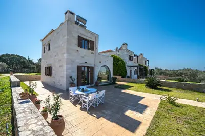 an external view of a house with a table and chairs at FOS residence - ΦΩΣ ,luxury villa in Chania Town