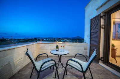 a patio with a table and chairs on a balcony at FOS residence - ΦΩΣ ,luxury villa in Chania Town