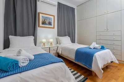 two beds in a bedroom with blue and white at DIMITRA apartment with private pool and sea view -the ground floor of a two storey building in Daratso