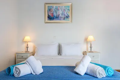 a bedroom with a bed with towels on it at DIMITRA apartment with private pool and sea view -the ground floor of a two storey building in Daratso