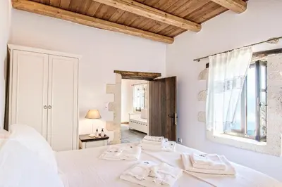 a bedroom with a white bed and a mirror at Sclopa The Laography Project in Kolymvari