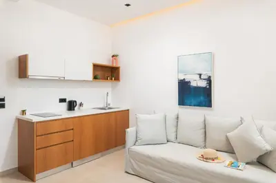 a living room with a couch and a kitchen at Diamond Star Hotel in Falasarna