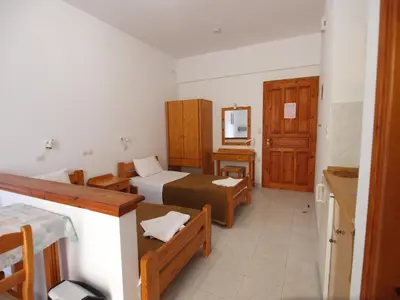 a hotel room with two beds and a bathroom at Irini Apartments in Plataniás